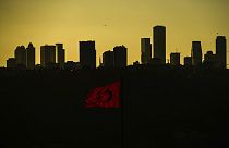 FILE - The sun sets behind high buildings of a financial business area in Istanbul, Turkey, Friday, March 22, 2024. 