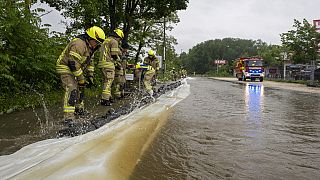 Firefighters work on a street flooded by the Günz in Ichenhausen, Germany, Saturday, June 1, 2024.  (Stefan Puchner/dpa via AP)