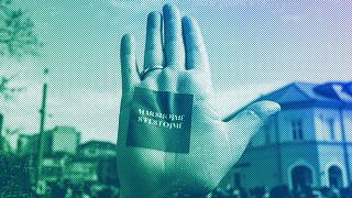 A woman holds up her hand with a sticker that reads: "We March, we aren't Celebrating", during a rally to ask for more respect for women's rights in Prishtina, March 2021