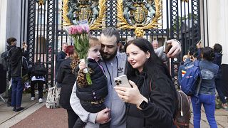 A family poses for a selfie photograph outside of Buckingham Palace in London, two days after Queen Elizabeth II died at the age of 96. September 10, 2022