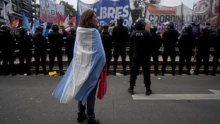 A demonstrator stands wrapped in an Argentine flag during a protest against food scarcity at soup kitchens and economic reforms proposed by President Javier Milei in Buenos A