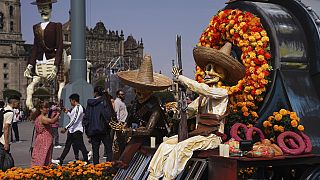 Visitors take photos of Day of the Dead themes presentations at Mexico City´s main square the Zocalo, Tuesday, Oct. 31, 2023.