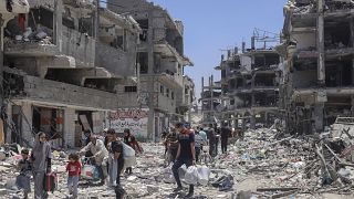 Palestinians walk through the destruction in the wake of an Israeli air and ground offensive in Jabaliya, May 30, 2024