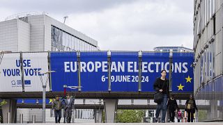 People walk outside the European Parliament prior to a debate with the lead candidates for the European Parliament elections in Brussels, Thursday, May 23, 2024. 