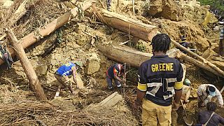 Villagers search amongst the debris from a landslide in the village of Yambali in the Highlands of Papua New Guinea, Monday, May 27, 2024.