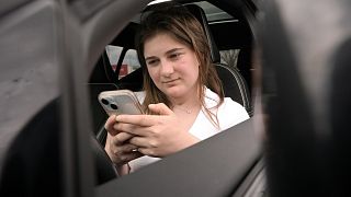 Alexis Bogan, whose speech was impaired by a brain tumour, uses an AI powered smartphone app to create a audible drink order at a Starbucks.