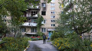 A man walks in front of a building that was damaged by a missile in Irpin, near Kyiv, Ukraine