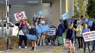 People protest outside an Auckland school near where a vape shop was set to open, Aug 1, 2023.