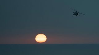 An MH-60S Seahawk helicopter flies back to the U.S.S. aircraft carrier Dwight D. Eisenhower, also known as the 'IKE', in the south Red Sea