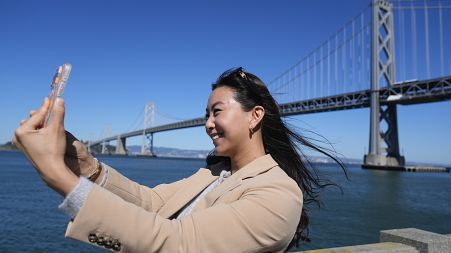 Content creator Cynthia Huang Wang works below the San Francisco-Oakland Bay Bridge in San Francisco, Monday, April 8, 2024.