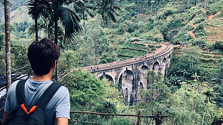 A walker looks over the Nine Arch Bridge, Sri Lanka. 