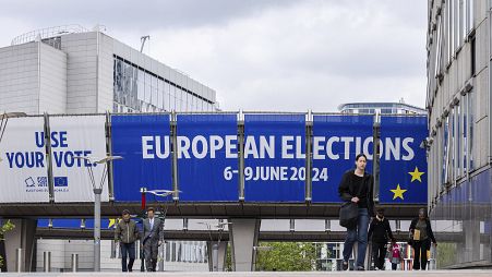 People walk outside the European Parliament prior to a debate with the lead candidates for the European Parliament elections in Brussels, Thursday, May 23, 2024. 