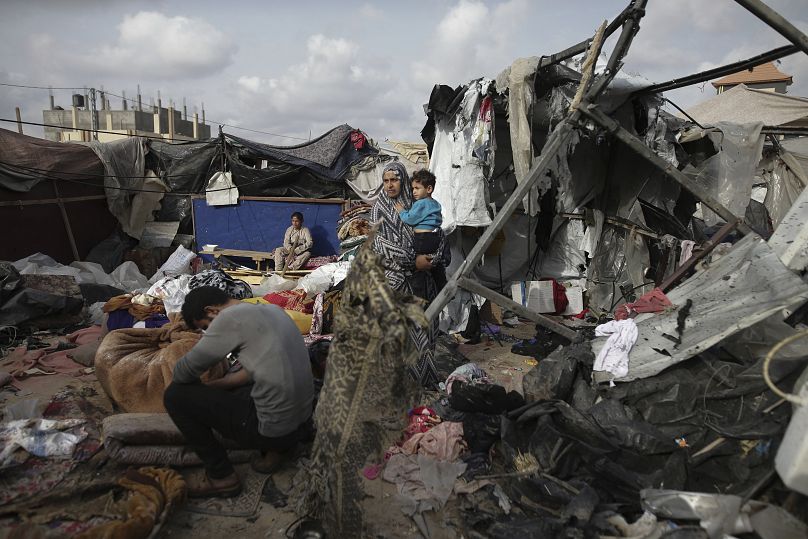 Displaced Palestinians inspect their tents destroyed by an Israeli strike west of Rafah, May 28, 2024